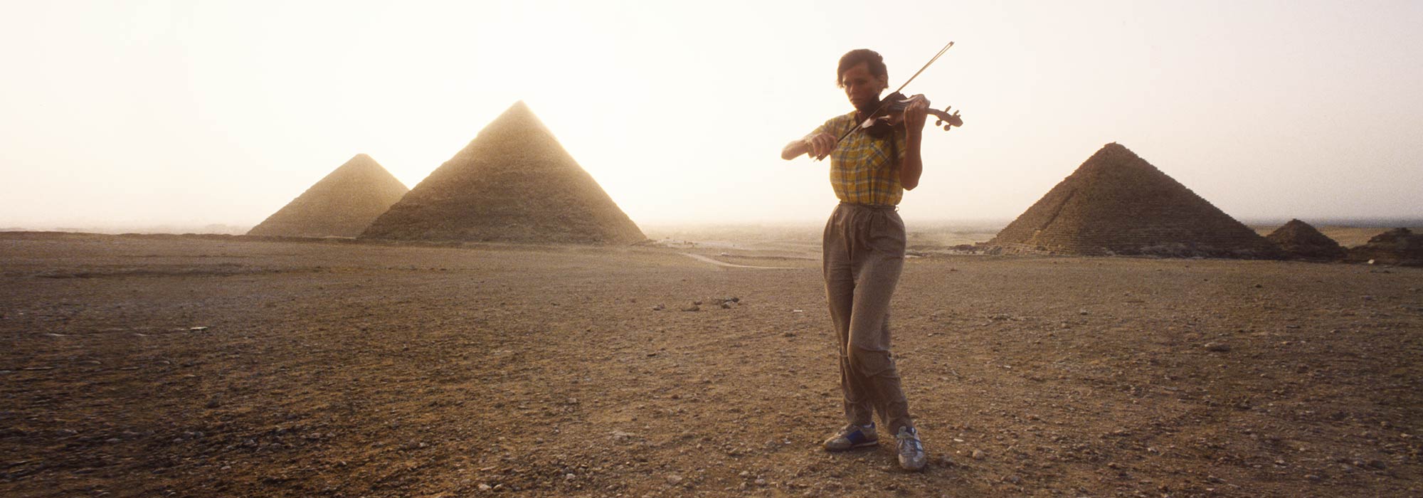 Violinist Playing Near Pyramids